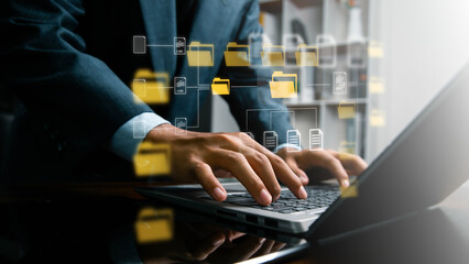 Obraz premium Businessman using laptop with digital file management system, Data export and privacy request concept showing document files and folders being downloaded from an account system,secure management
