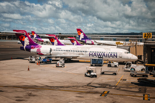 Airport ground crew member operating a service cart on the ramp with a Hawaiian Airlines Boeing  parked at terminal gate A19, Daniel K. Inouye International Airport, Honolulu,