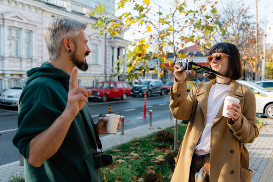 Friends enjoying street photography and coffee on an autumn afternoon in a city neighborhood