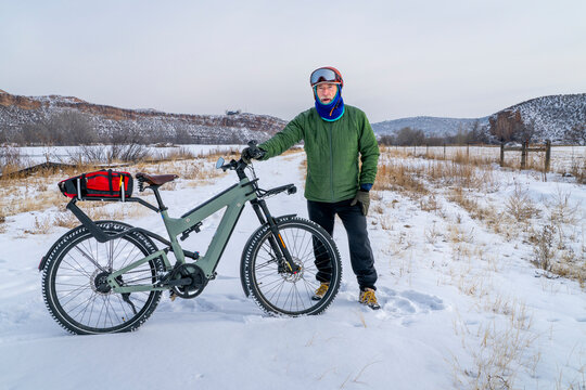 senior male cyclist with a touring electric bike in Colorado foothills in winter scenery