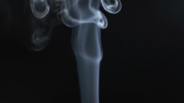 Wispy ethereal wisps of translucent grey vapor ascend in swirling amorphous formations against a deep obsidian void, creating an atmospheric and mysterious visual of atmospheric phenomenon