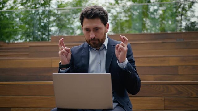 Caucasian businessman waiting wishing looking at laptop outdoors in city betting business man online work studying guy male worker architect real estate agent computer screen expect pray luck gambling