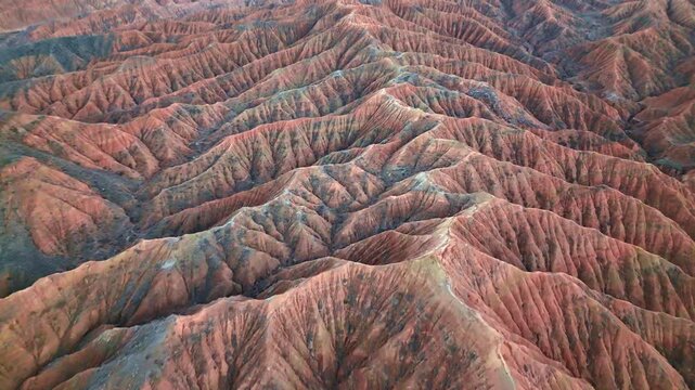 Aerial drone over red badlands formations of Ak-Sai Canyon near Issyk-Kul southern shore, Kyrgyzstan
