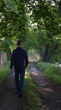 Man walking on path with misty fog and sun rays. Active lifestyle