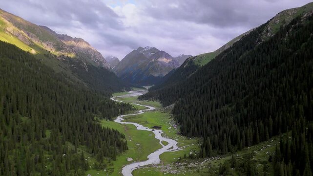 Wide aerial panorama of Jeti-Oguz with braided river and Terskey Ala-Too snow peaks, Kyrgyzstan