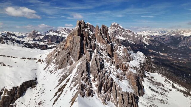 Aerial flight along snow-covered Croda da Lago ridge with vast mountain panorama on Tofane, Cortina, Italy