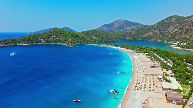 Aerial view of Oludeniz Beach, Turkey and blue bay. Turquoise water, sandy beach and distant mountains create a scenic summer view.