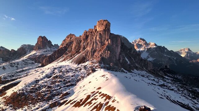 Drone orbit of Ra Gusela peak at sunset with Dolomite panorama behind, Cortina, Italy