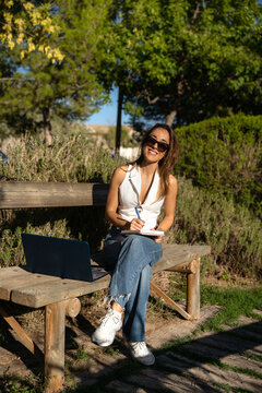 Digital nomad woman freelancing outdoors with laptop