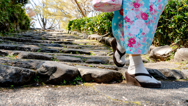 Woman in kimono walking stone path in Maruyama Park