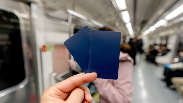 Hand holding blank blue ticket on subway during travel