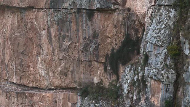 Tiny monastery on vast vertical cliff showing extreme scale, Tzoumerka, Epirus, Greece