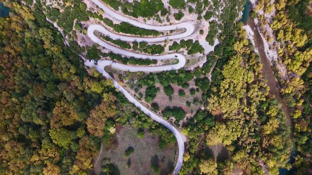 Dramatic switchback road cutting through autumn forest in Greek mountains, Zagori, Epirus