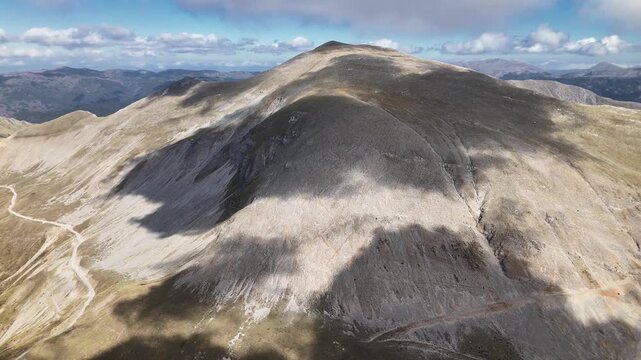 Clouds rolling over mountain pass summit with road visible below, Pindus range, Greece