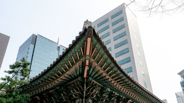 Deoksugung Palace roof with modern Seoul buildings behind