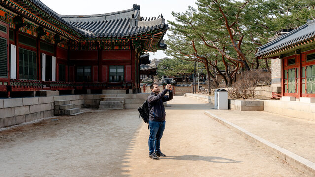 Tourist photographing Deoksugung Palace courtyard in Seoul