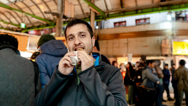 Man tasting pan fried beef at Gwangjang Market, Seoul