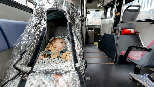 Baby in stroller on city bus during rainy day commute