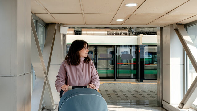 Woman with stroller waiting on Seoul subway platform