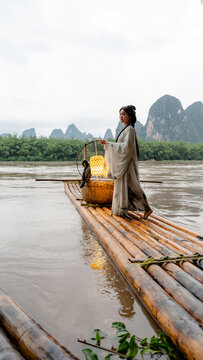 Hanfu girl on bamboo raft with cormorant in Xingping