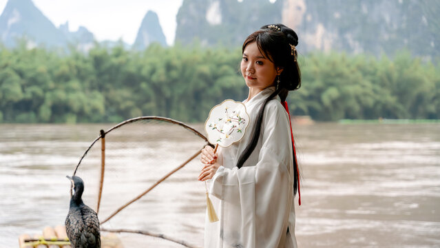 Hanfu girl with cormorant by River in Xingping, China