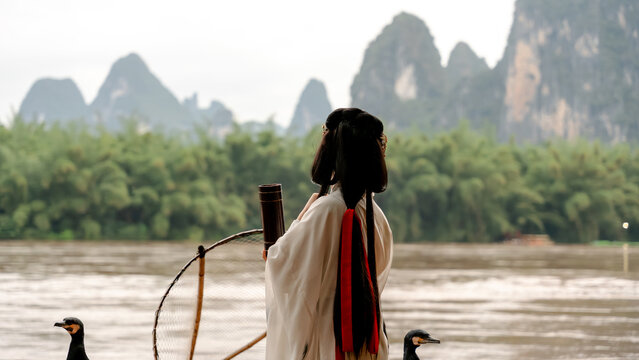 Hanfu girl with cormorant by Li River in Xingping
