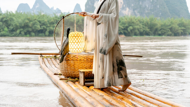 Hanfu girl with cormorant on bamboo raft in Xingping