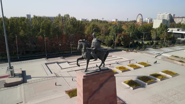 Aerial view of Ala-Too Square, the central public square of Bishkek, Kyrgyzstan. The wide open plaza, national flag, surrounding government buildings, and the urban landscape of the capital city.