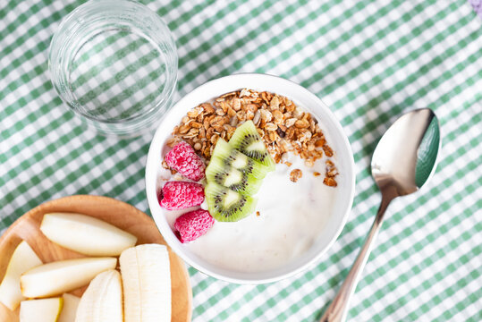 Yogurt bowl with granola oatmeal, kiwi and raspberry