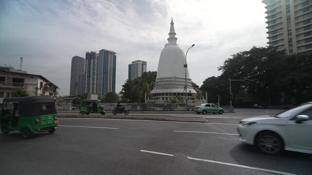 View of traffic passing the Fort Sambuddhaloka Buddhist temple, Fort, Colombo, Sri Lanka, Asia