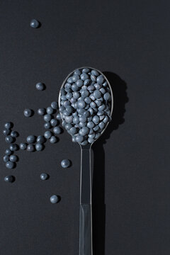 Black beluga lentils in spoon on dark background flatlay
