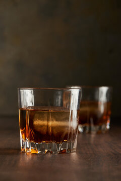 Close up of bourbon whisky in tumbler with ice cube