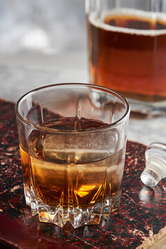 Glass of whisky bourbon with ice on stone tabletop
