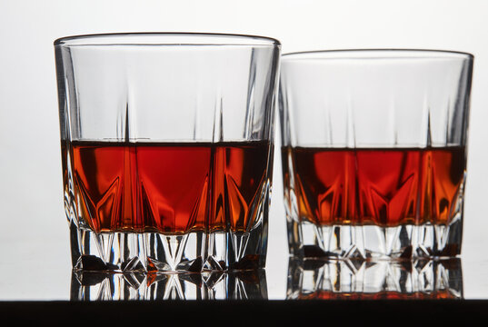 Close up of two bourbon whisky glasses on reflective bar