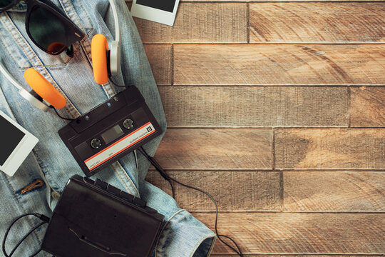 Retro cassette walkman with orange headphones on denim jacket