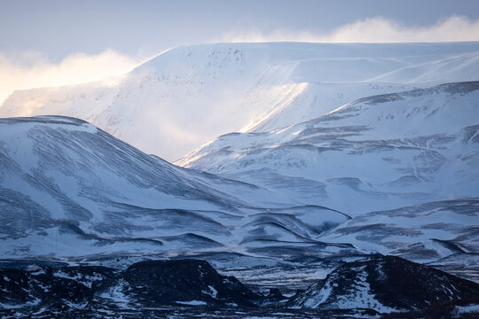 Snowy Icelandic mountains in winter with drifting mist