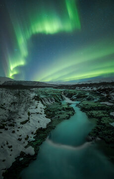Northern light over Bruarfoss waterfall in winter Iceland