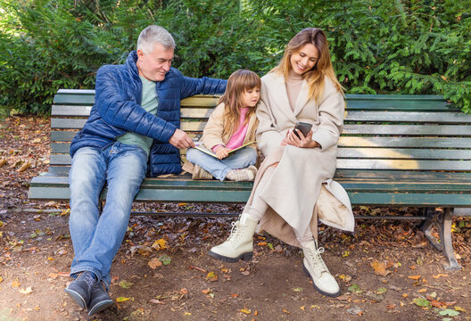 Three generation family on park bench sharing love