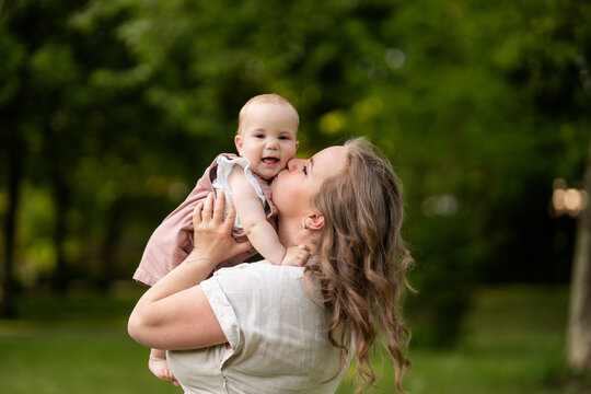 Happy mother holding baby girl during summer family time
