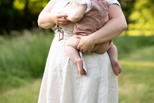 Happy summer family time holding baby girl outdoors
