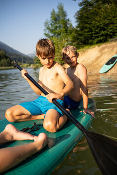 Children paddling on lake during summer vacation fun