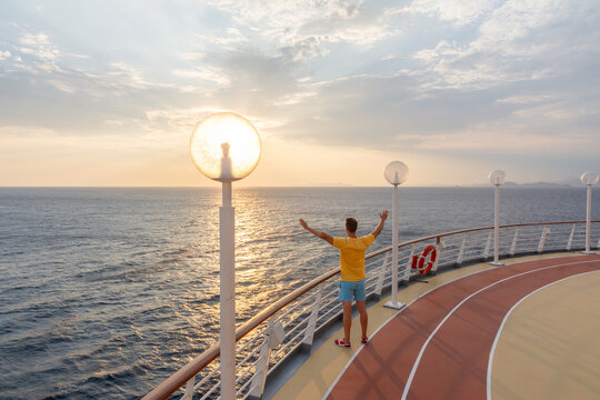 Man enjoying sunset freedom on a cruise ship deck