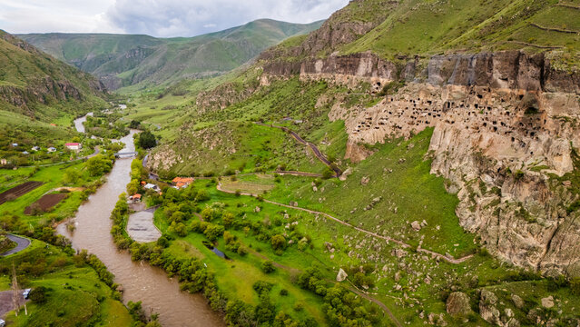Drone shot of Vardzia cave monastery, Georgia. Spectacular ancient rock-hewn fortress carved into Erusheti Mountain slopes above the winding Mtkvari River