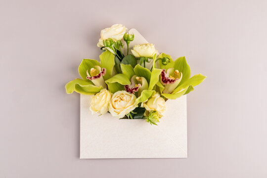 Floral envelope with roses and orchid on pastel background