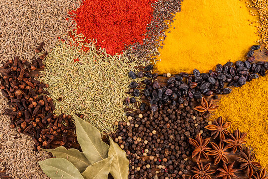 Assorted spices and seeds background with curry and pepper