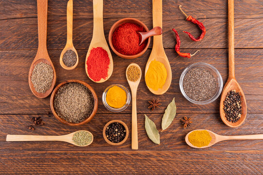 Assorted spices and seeds on wooden table, flat lay