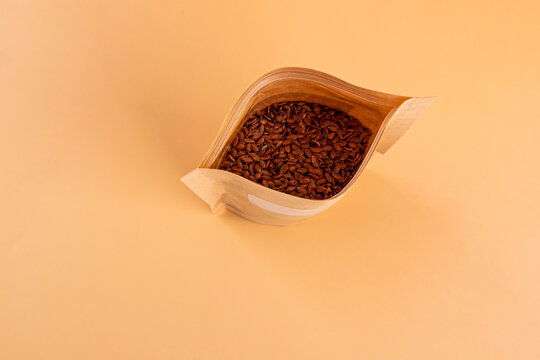 Flax seed in kraft pouch on beige background