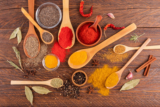 Colorful spices and seeds on wooden table, top view