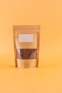 Stand-up kraft pouch with seeds on orange background