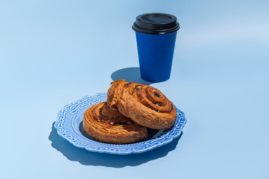 Coffee to go with pastries on blue plate